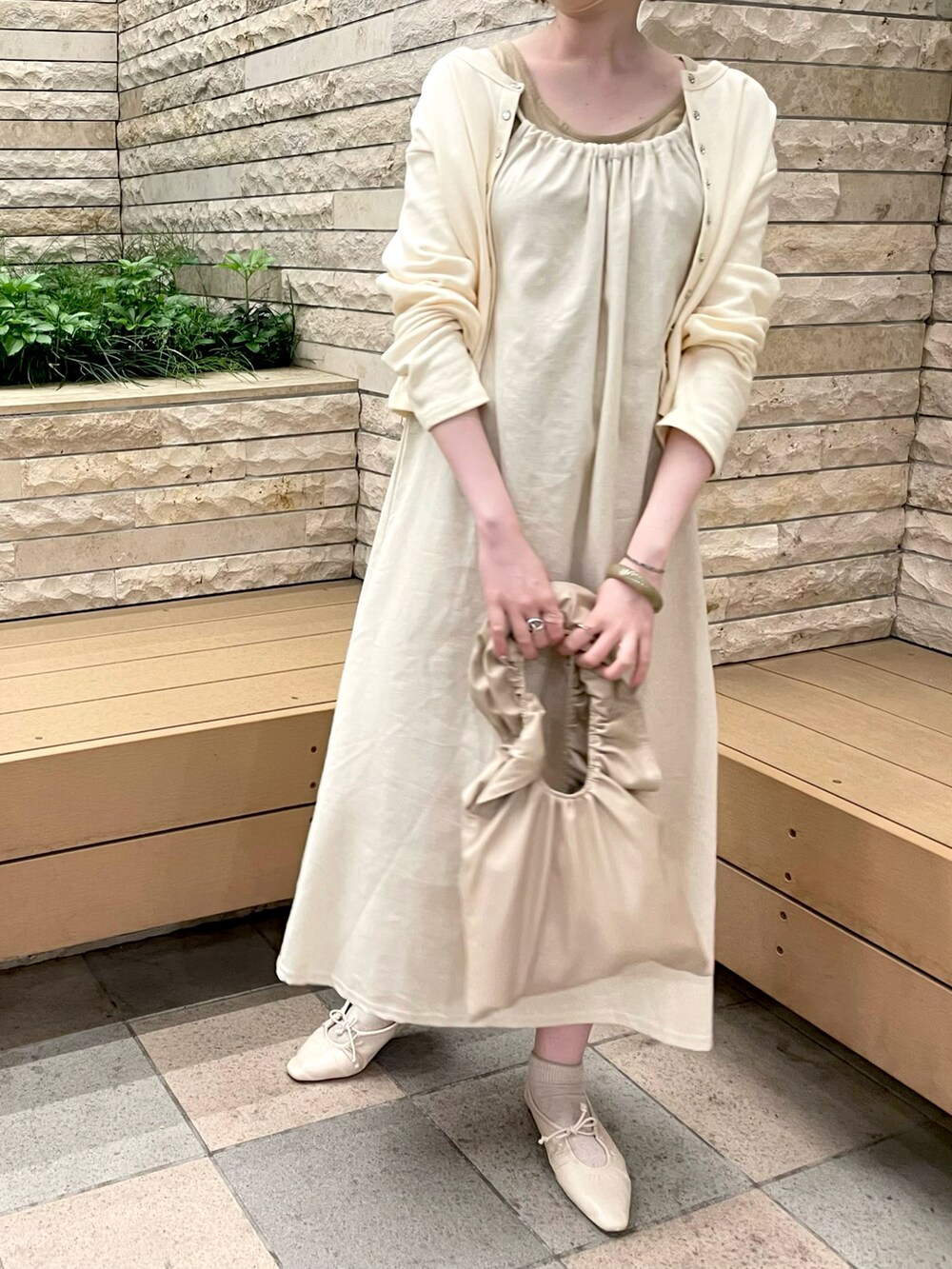 ベージュ系のパンプス、ベージュ系のワンピース/ドレス、ベージュ系のハンドバッグを着用したレディースの夏コーディネートの2枚目の写真