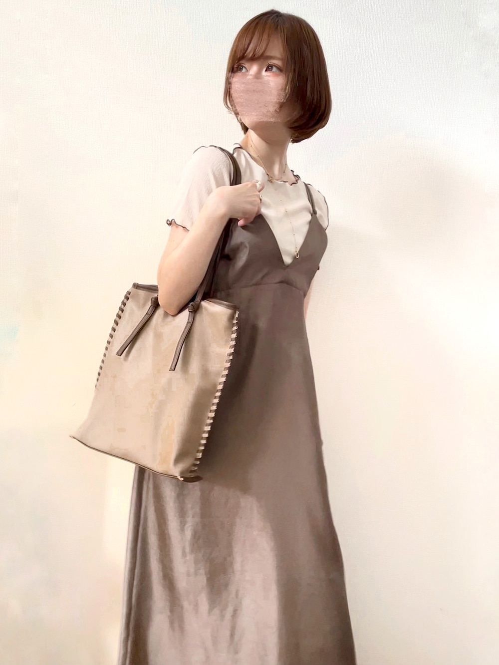 ブラウン系のワンピース、ベージュ系のトートバッグ、ベージュ系のトップスを着用したレディースの夏コーディネートの2枚目の写真