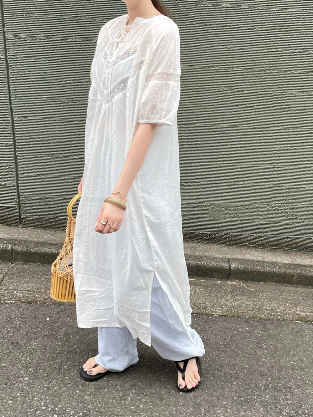 ホワイト系のワンピース、ベージュ系のかごバッグを着用したレディースの秋コーディネートの4枚目の写真