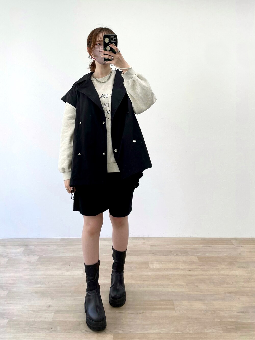 ブラック系のミリタリージャケット、ブラック系のブーツを着用したレディースの春コーディネートの2枚目の写真