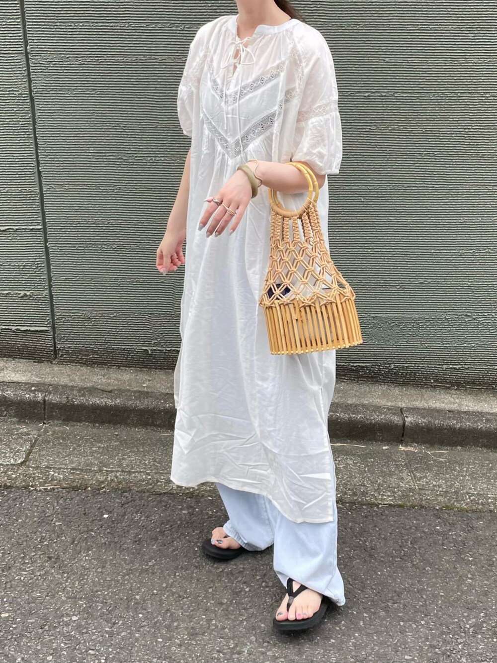 ホワイト系のワンピース、ベージュ系のかごバッグを着用したレディースの秋コーディネートの2枚目の写真