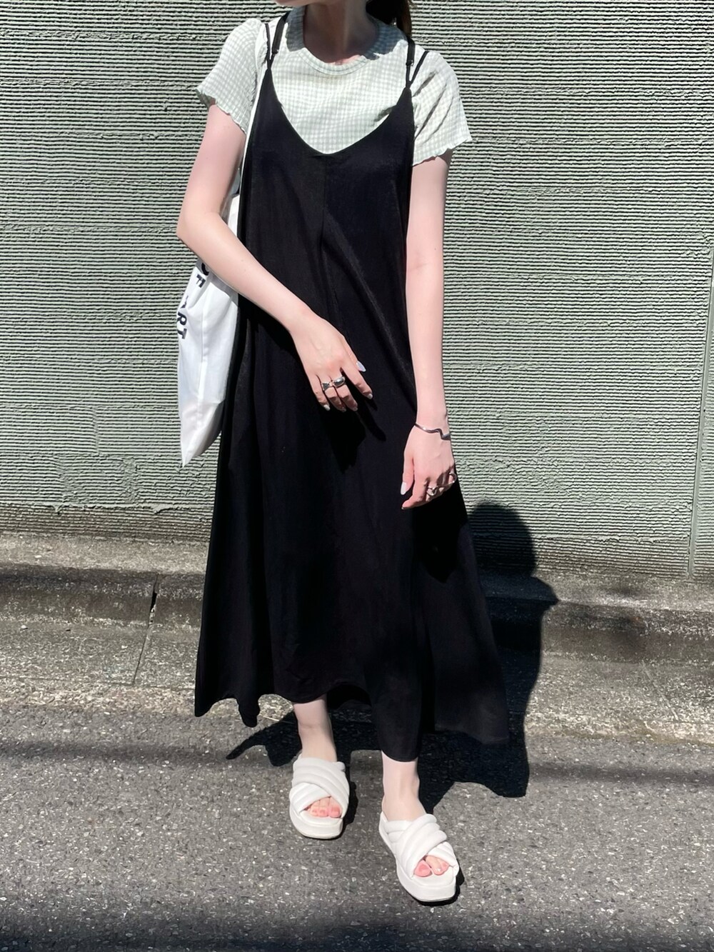ブラック系のワンピース、ホワイト系のサンダルを着用したレディースの夏コーディネートの4枚目の写真