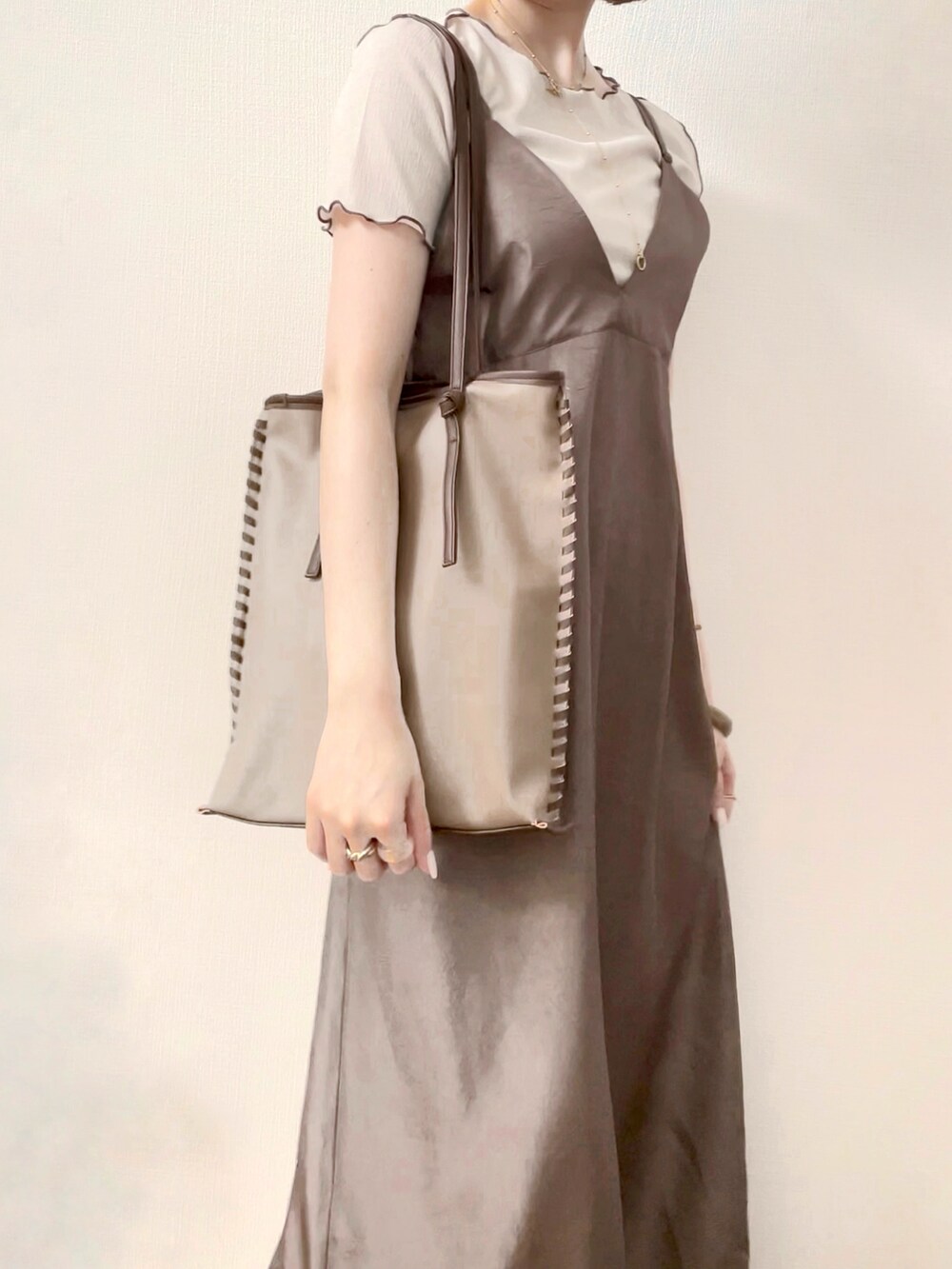 ブラウン系のワンピース、ベージュ系のトートバッグ、ベージュ系のトップスを着用したレディースの夏コーディネートの3枚目の写真