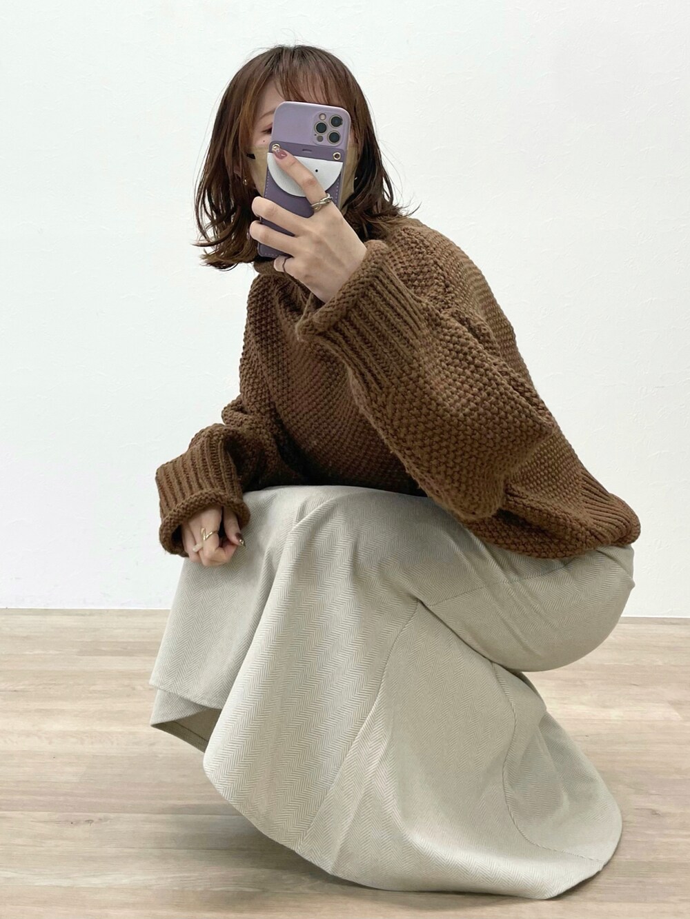 ホワイト系のスカート、イエロー系のニット/セーター、ブラック系のブーツを着用したレディースの冬コーディネートの2枚目の写真