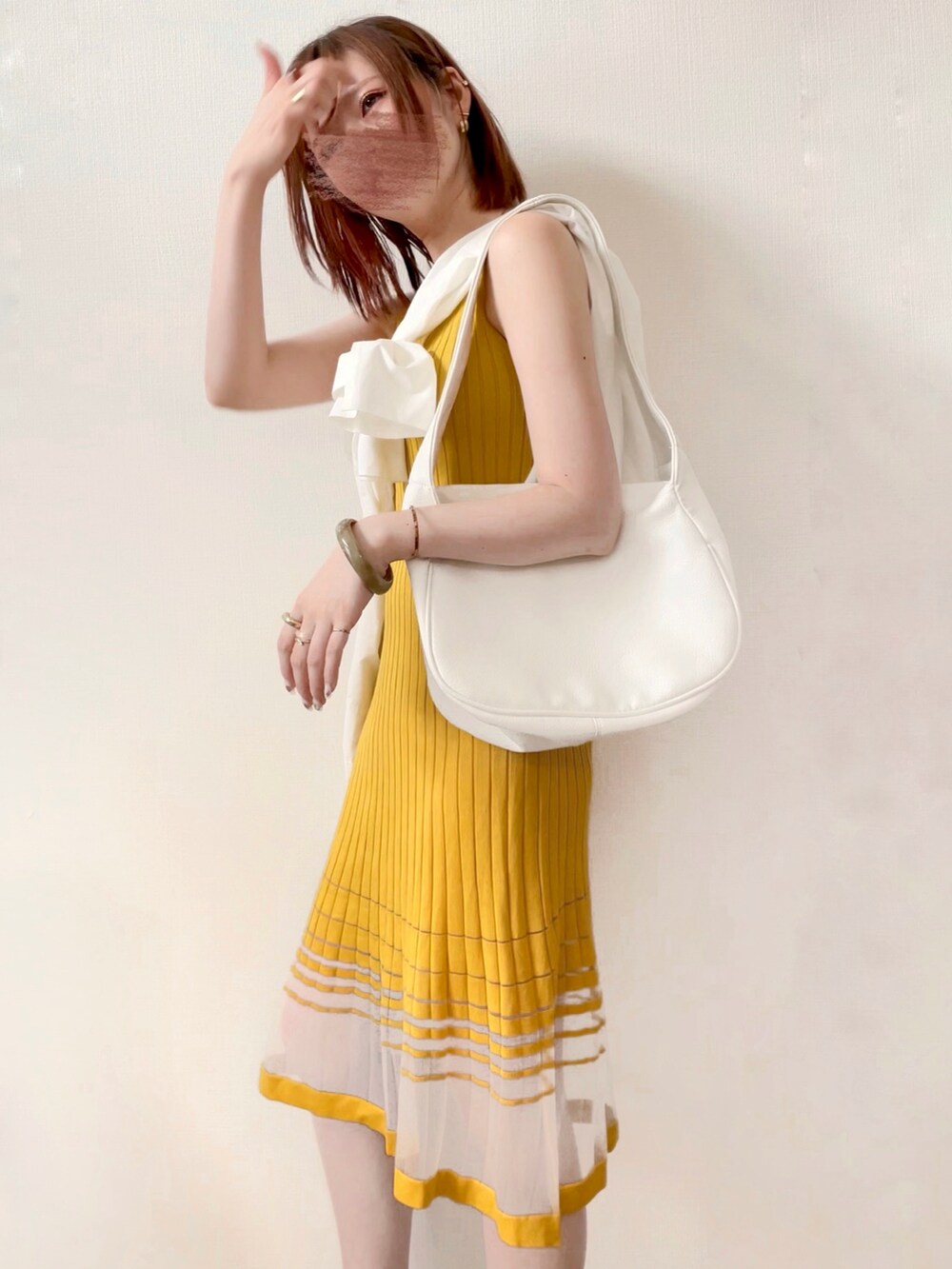 イエロー系のワンピース、グレー系のバングル/リストバンドを着用したレディースの夏コーディネートの3枚目の写真