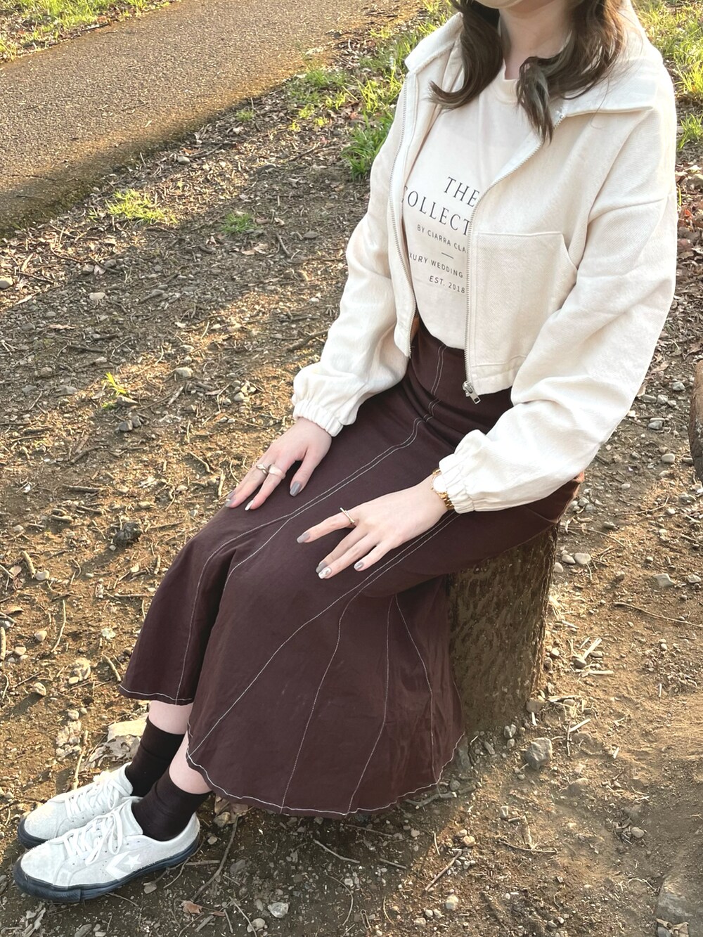 ホワイト系のジャケット/アウター、ブラウン系のスカート、ホワイト系のスニーカーを着用したレディースの春コーディネートの2枚目の写真