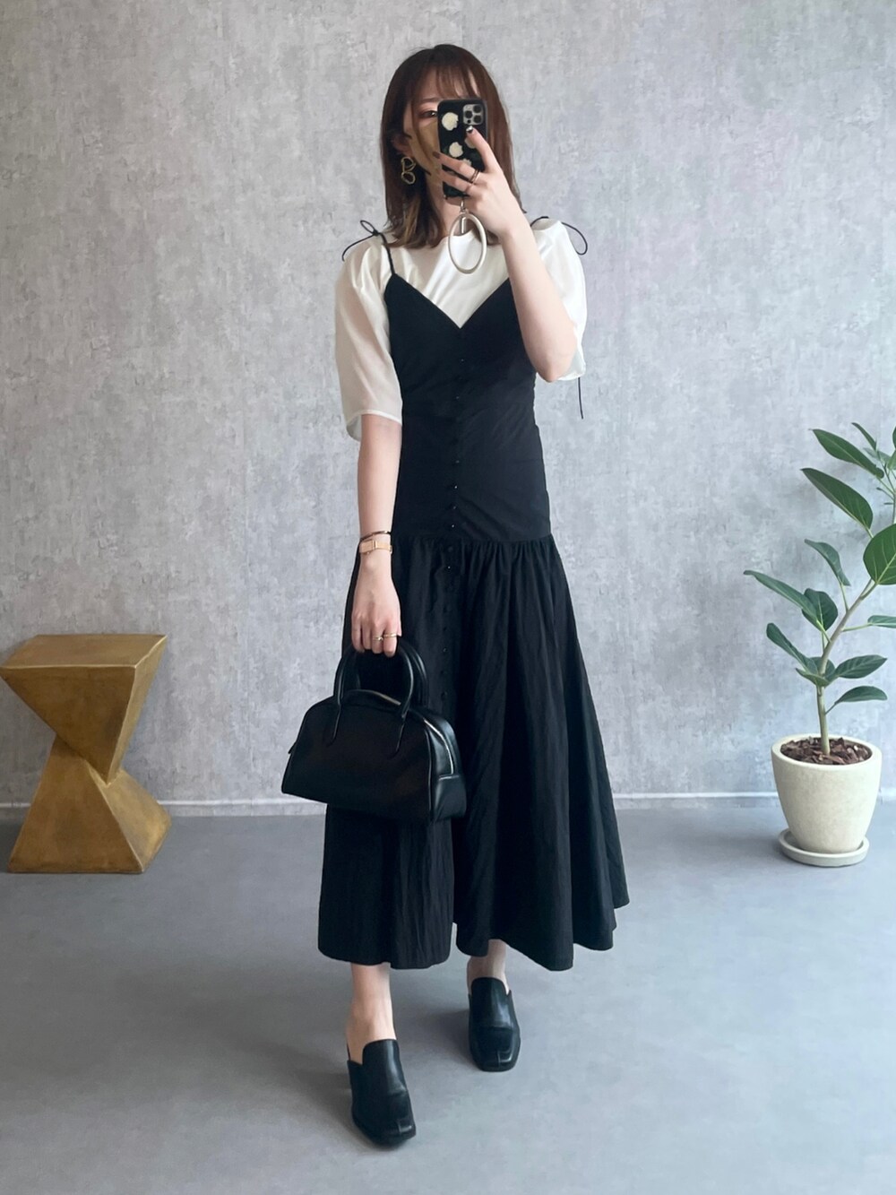 ホワイト系のシャツ/ブラウス、ブラック系のボストンバッグ、ブラック系のローファーを着用したレディースの夏コーディネートの5枚目の写真