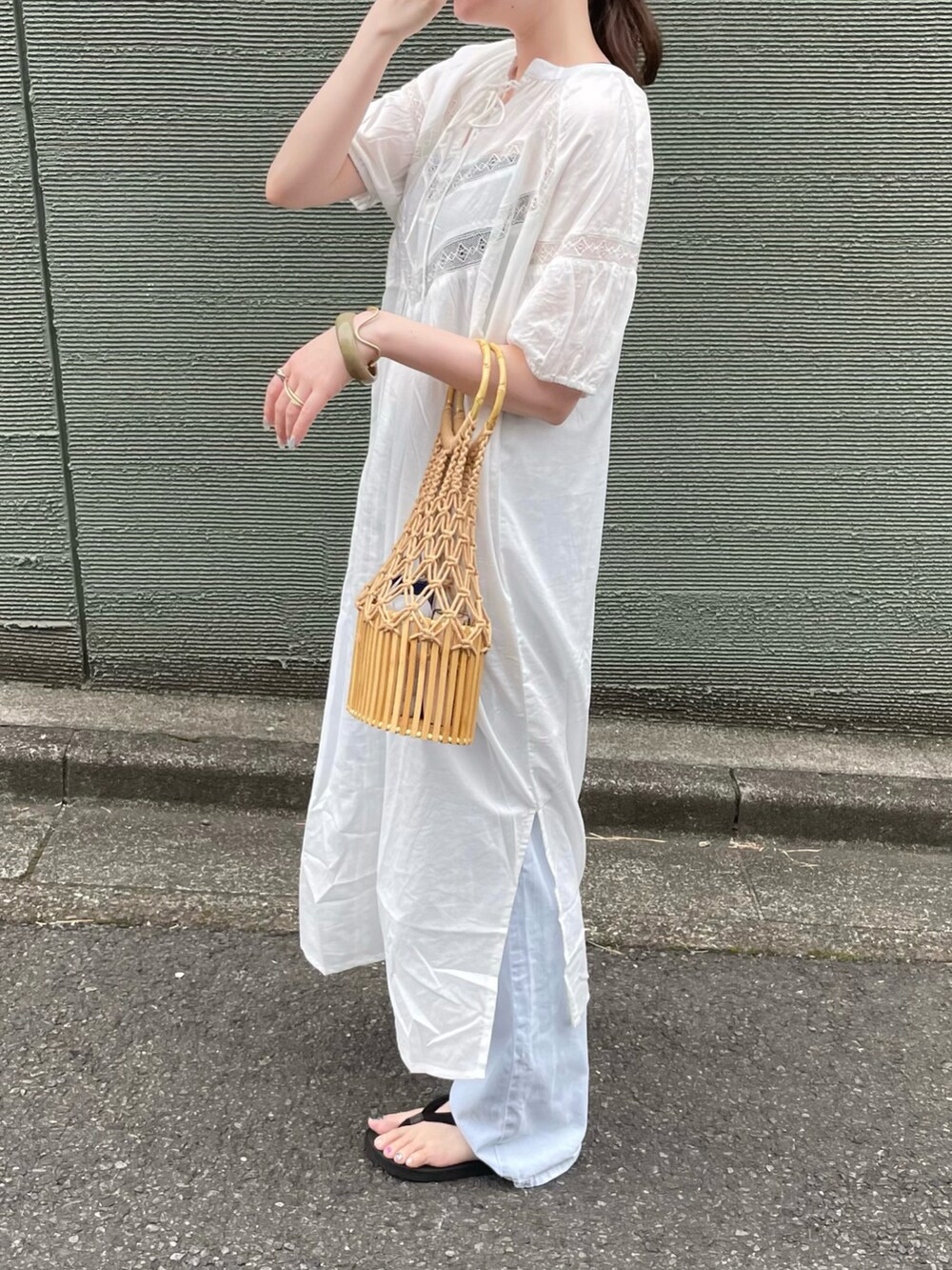 ホワイト系のワンピース、ベージュ系のかごバッグを着用したレディースの秋コーディネートの3枚目の写真