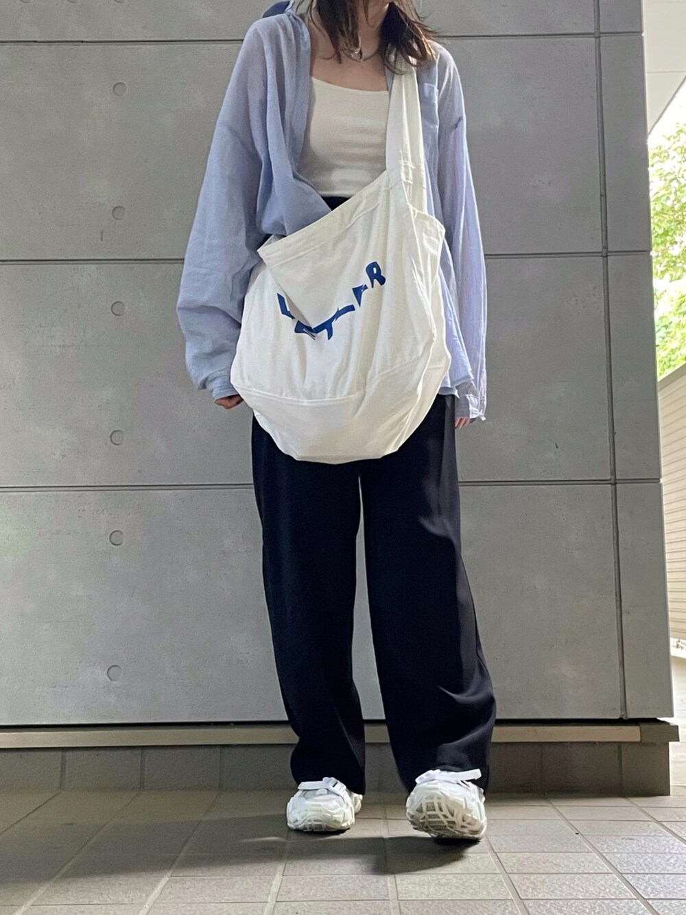 ブラック系のチノパンツを着用したレディースの秋コーディネートの3枚目の写真