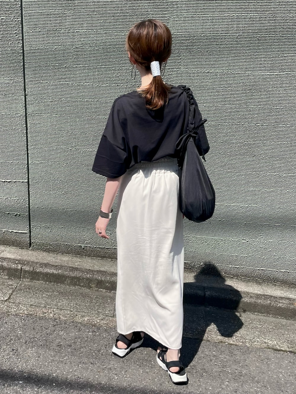 ブラック系のTシャツ/カットソー、ブラック系のショルダーバッグ、ブラック系のサンダルを着用したレディースの夏コーディネートの5枚目の写真