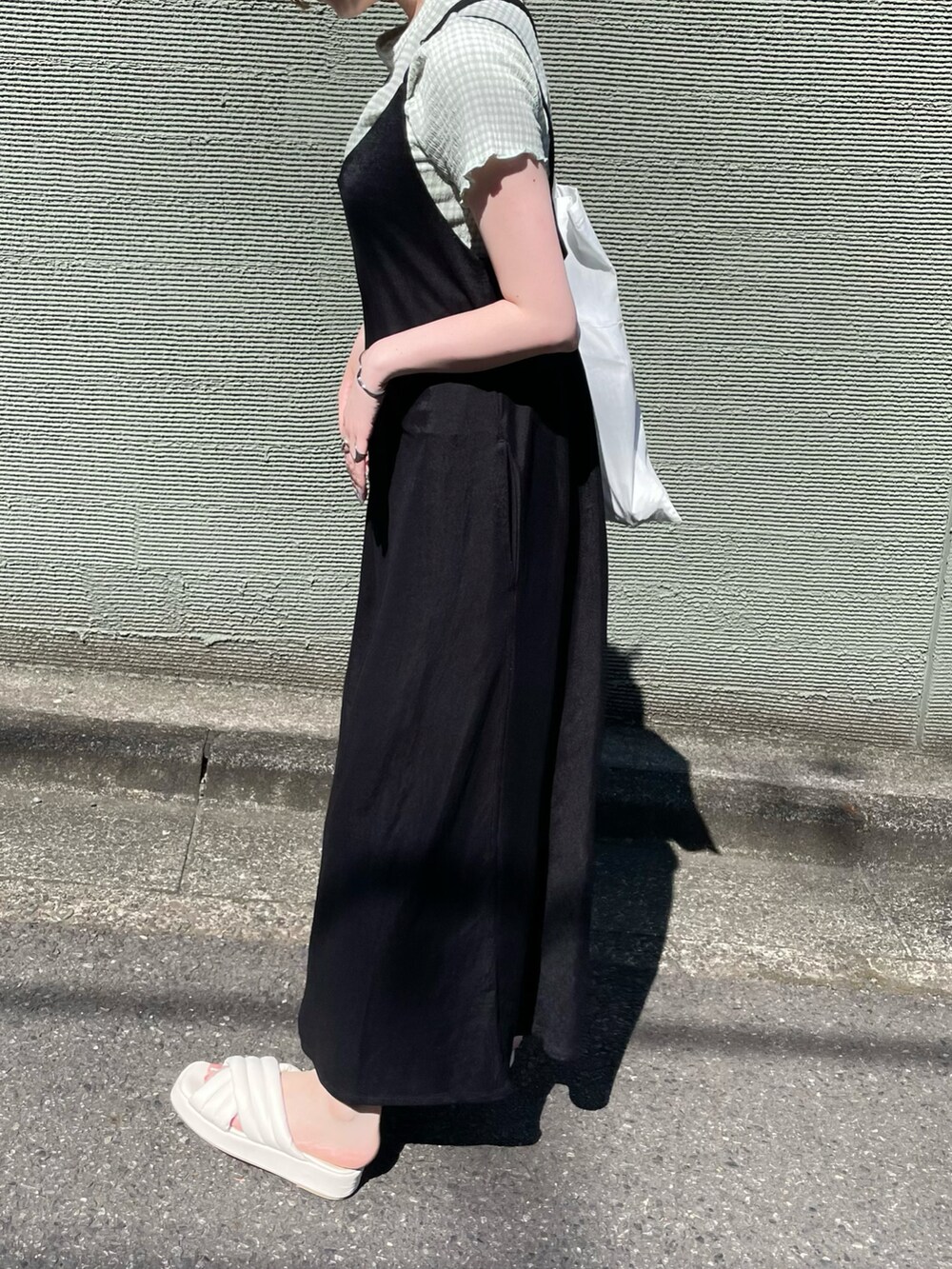 ブラック系のワンピース、ホワイト系のサンダルを着用したレディースの夏コーディネートの3枚目の写真