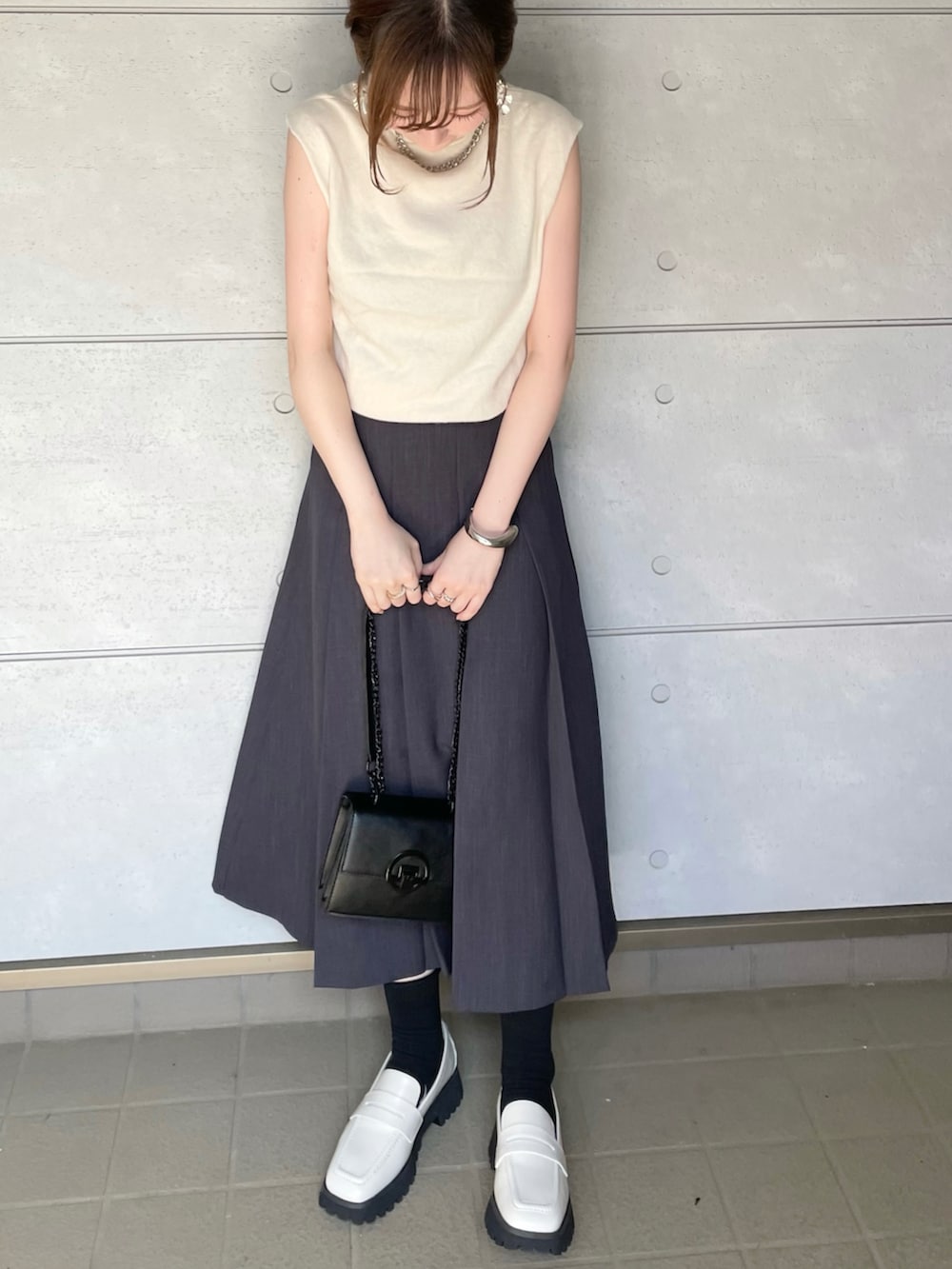 ホワイト系のローファーを着用したレディースの秋コーディネートの2枚目の写真