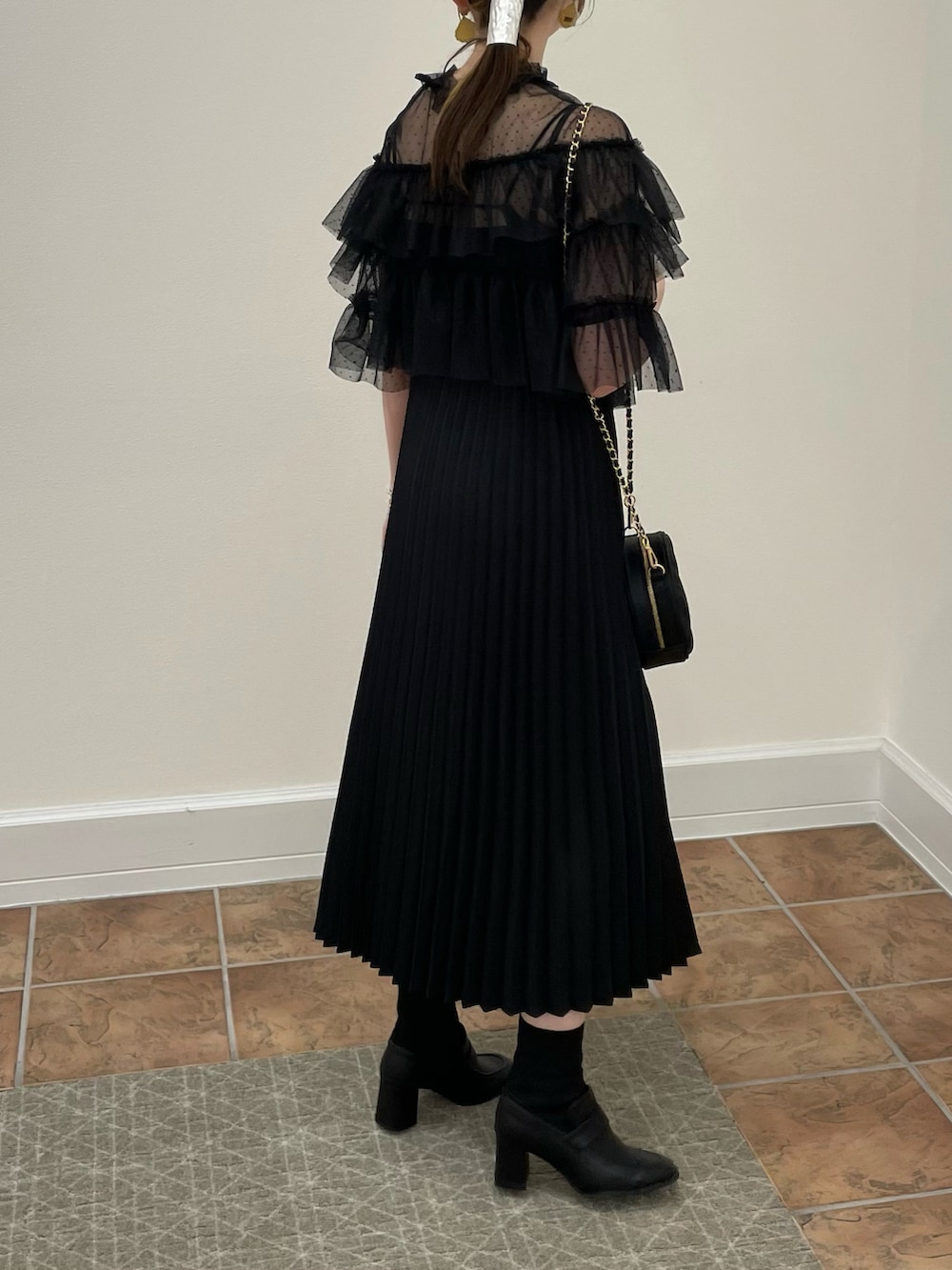 ブラック系のドレス、ブラック系のハンドバッグ、ブラック系のローファーを着用したレディースの秋コーディネートの4枚目の写真