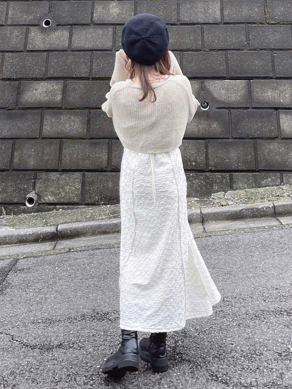 ホワイト系のワンピース、ブラック系のハンドバッグ、ベージュ系のカーディガン/ボレロを着用したレディースの秋コーディネートの2枚目の写真