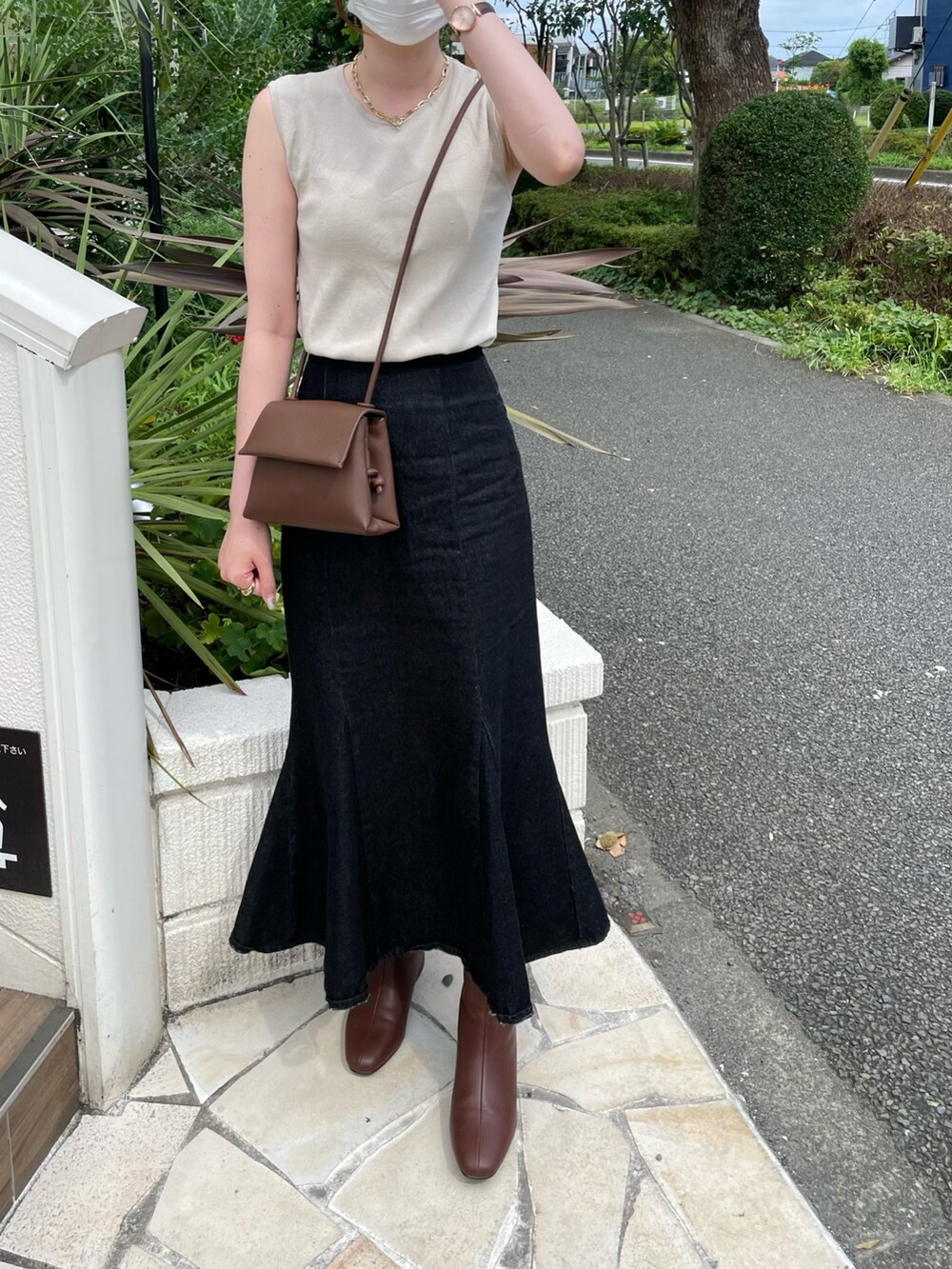 ブラウン系のブーツ、ブラック系のデニムスカートを着用したレディースの夏コーディネートの2枚目の写真