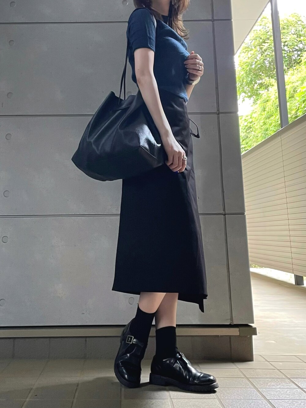 ブラック系のトートバッグ、ブラック系のシューズを着用したレディースの夏コーディネートの3枚目の写真