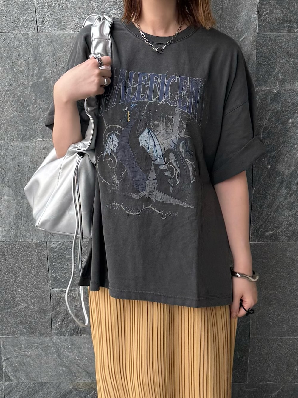 グレー系のTシャツ/カットソー、イエロー系のスカート、シルバー系のハンドバッグを着用したレディースの春コーディネートの4枚目の写真