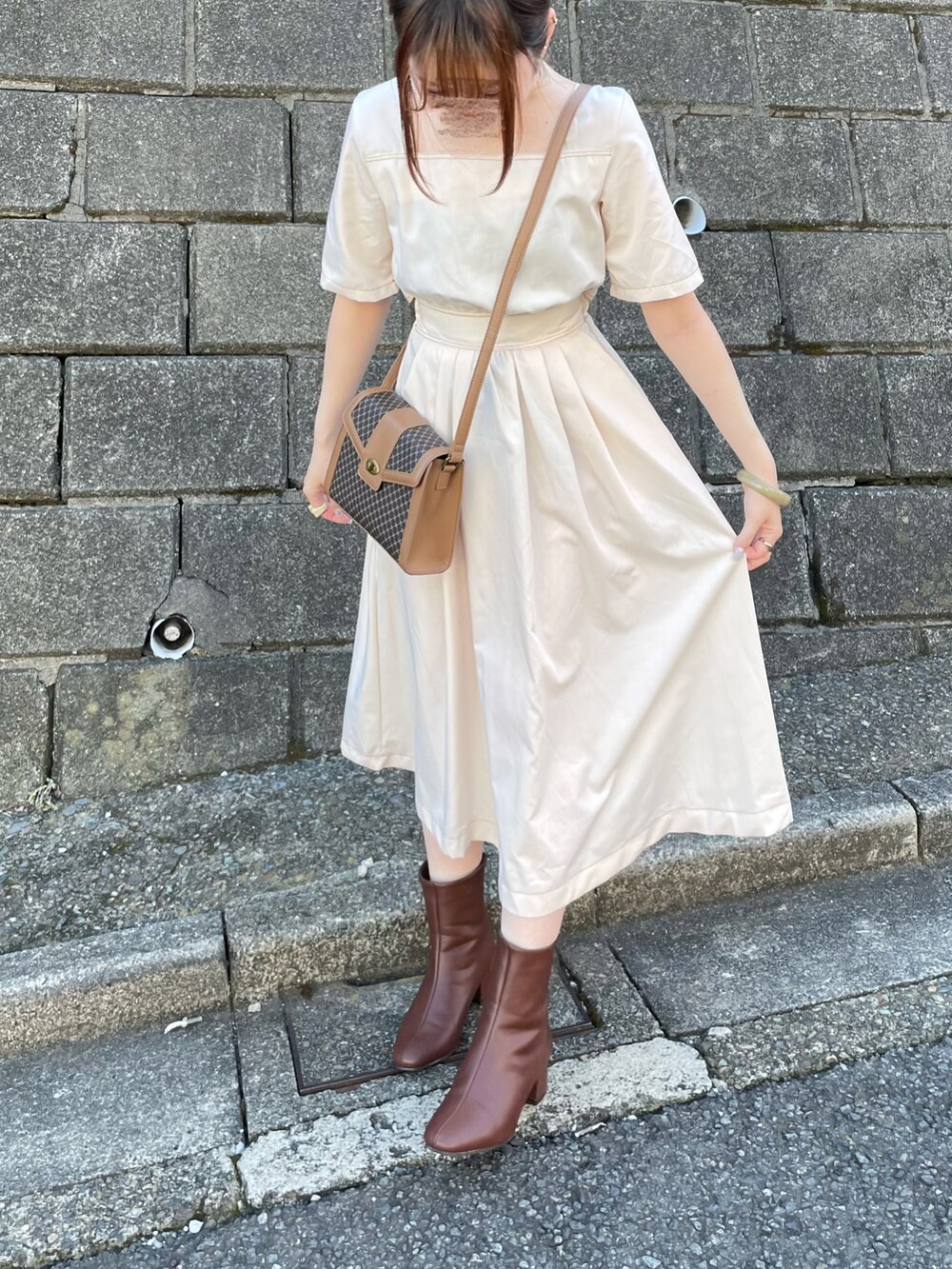 ブラウン系のブーツ、ブラウン系のショルダーバッグを着用したレディースの秋コーディネートの3枚目の写真