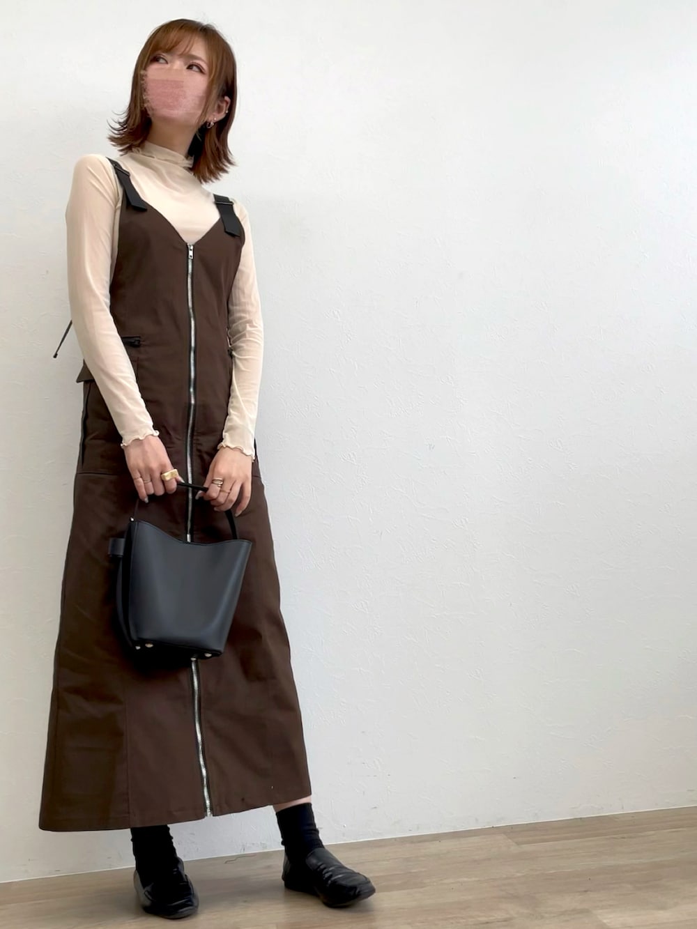 ブラウン系のジャンパースカート、ブラック系のローファーを着用したレディースの秋コーディネートの2枚目の写真