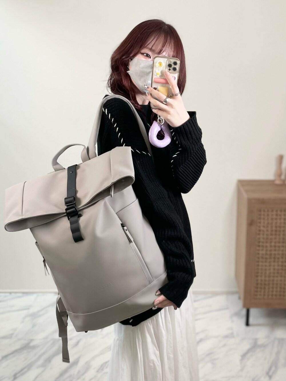 ブラック系のニット/セーター、ホワイト系のスカート、グレー系のバックパック/リュックを着用したレディースの秋コーディネートの5枚目の写真