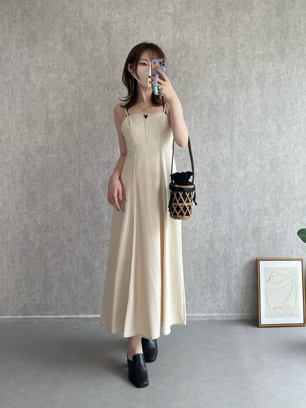 ホワイト系のワンピース、ブラック系のかごバッグ、ブラック系のローファーを着用したレディースの秋コーディネートの3枚目の写真