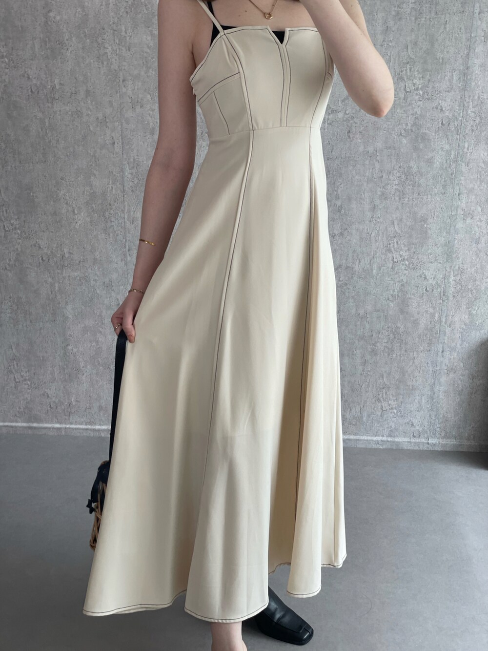 ホワイト系のワンピース、ブラック系のかごバッグ、ブラック系のローファーを着用したレディースの秋コーディネートの5枚目の写真