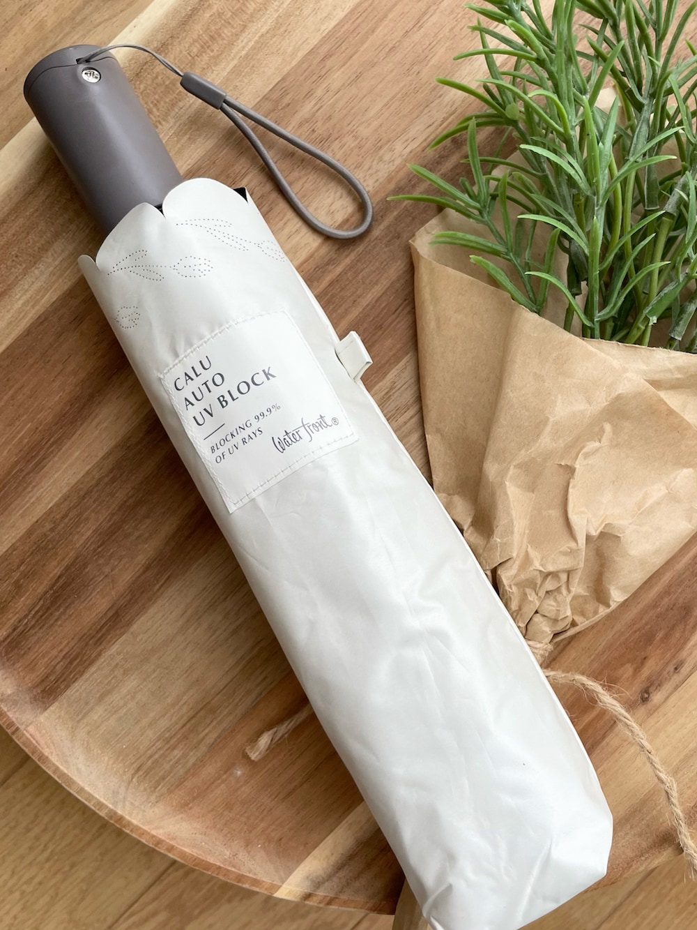 ホワイト系の折りたたみ傘を着用したレディースの夏コーディネートの3枚目の写真