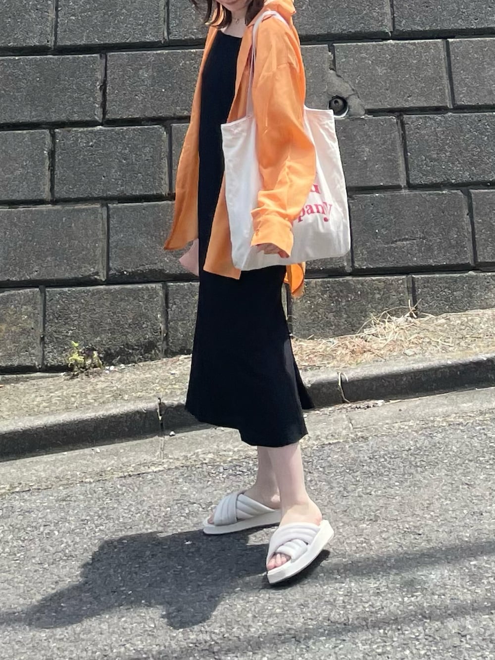 オレンジ系のシャツ/ブラウス、ホワイト系のトートバッグ、ホワイト系のサンダルを着用したレディースの夏コーディネートの4枚目の写真