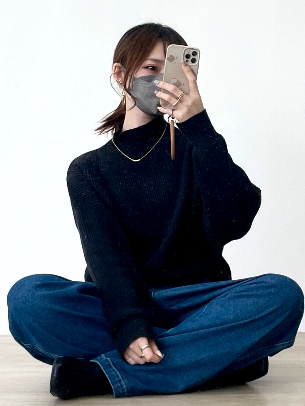 ブルー系のデニムパンツ、ブラック系のニット/セーターを着用したレディースの冬コーディネートの4枚目の写真