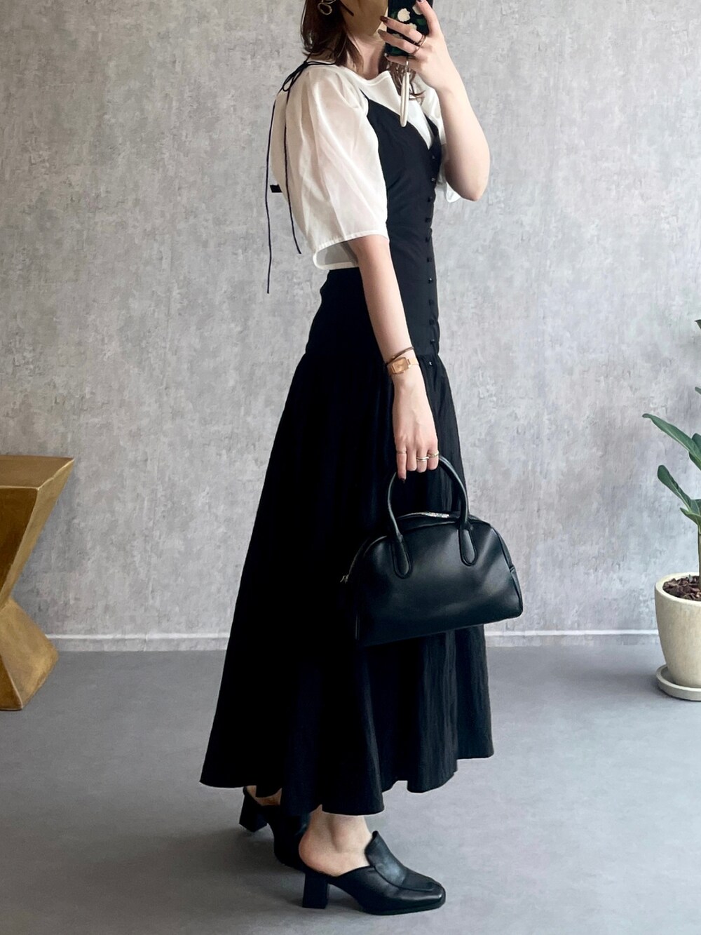 ホワイト系のシャツ/ブラウス、ブラック系のボストンバッグ、ブラック系のローファーを着用したレディースの夏コーディネートの4枚目の写真