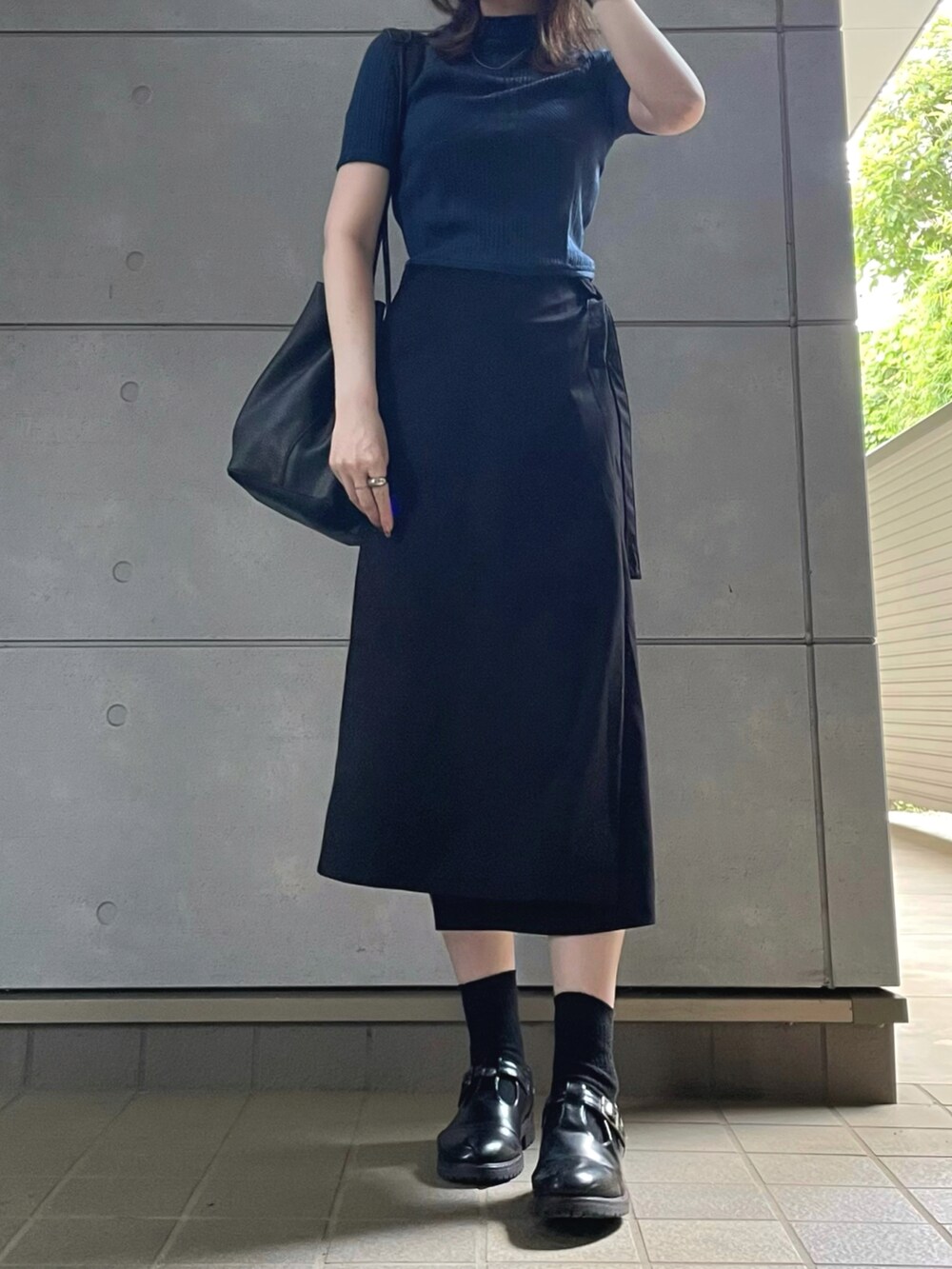 ブラック系のトートバッグ、ブラック系のシューズを着用したレディースの夏コーディネートの2枚目の写真