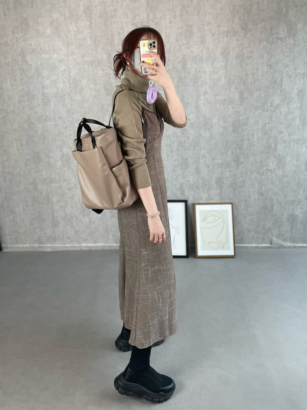 ベージュ系のトップス、ブラウン系のワンピース、ベージュ系のバックパック/リュックを着用したレディースの冬コーディネートの5枚目の写真