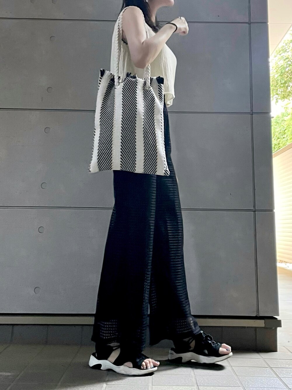 ブラック系のサンダル、ブラック系のその他パンツを着用したレディースの秋コーディネートの3枚目の写真