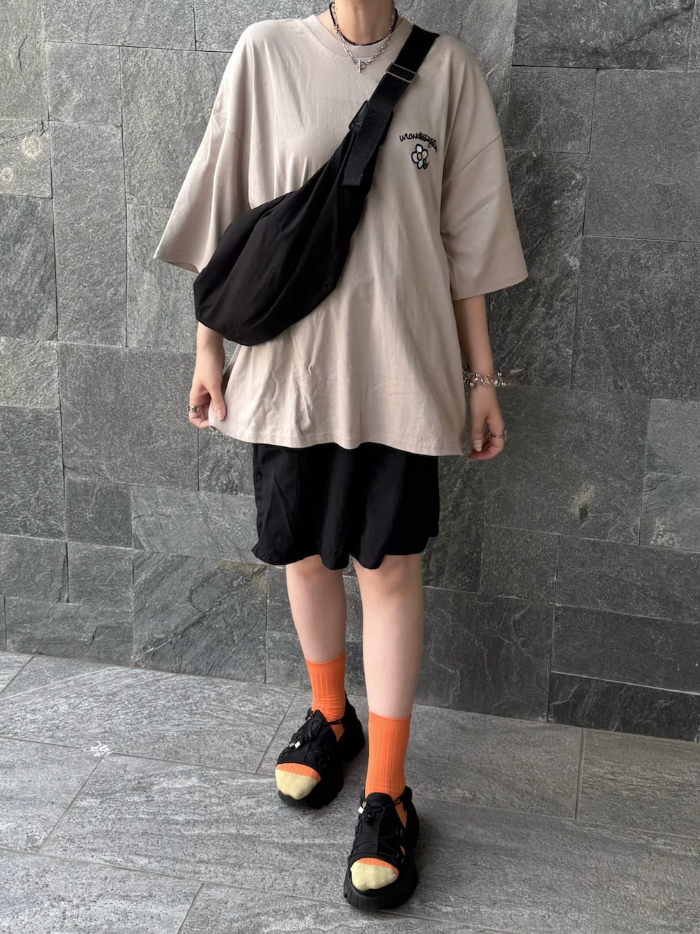 ベージュ系のTシャツ/カットソーを着用したレディースの夏コーディネートの2枚目の写真