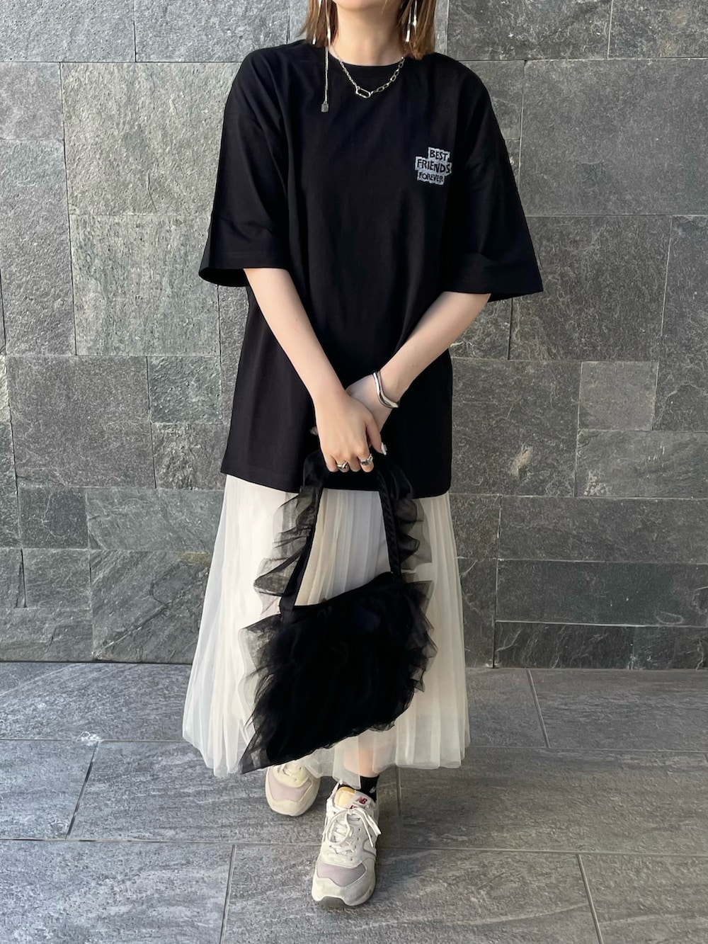 ブラック系のTシャツ/カットソー、ホワイト系のスカート、ブラック系のショルダーバッグを着用したレディースの春コーディネートの5枚目の写真