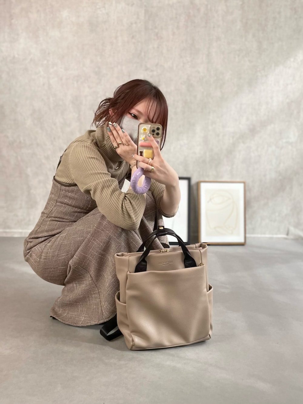 ベージュ系のトップス、ブラウン系のワンピース、ベージュ系のバックパック/リュックを着用したレディースの冬コーディネートの2枚目の写真