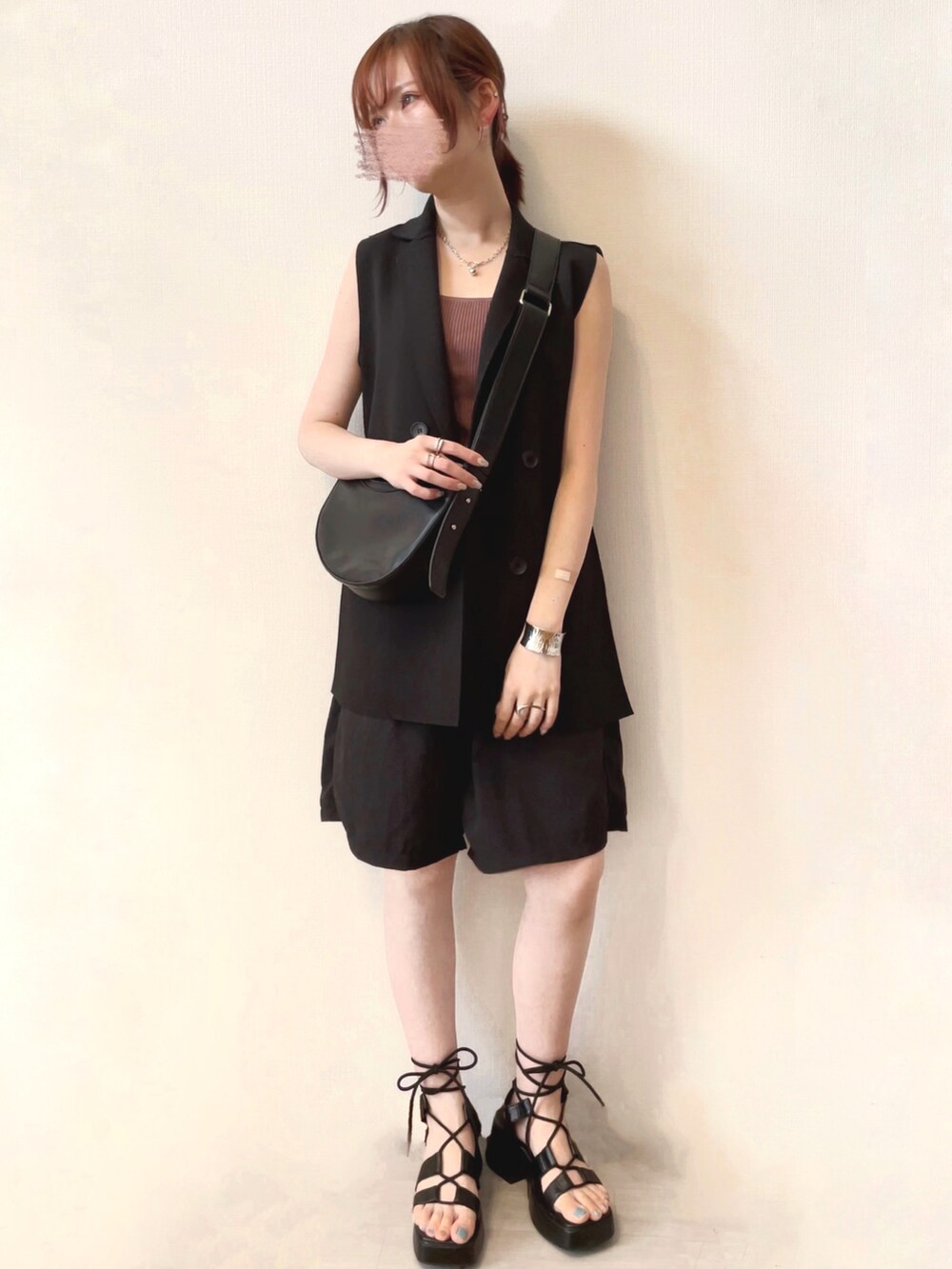 ブラック系のシューズ、ブラック系のベスト、ピンク系のタンクトップを着用したレディースの夏コーディネートの2枚目の写真