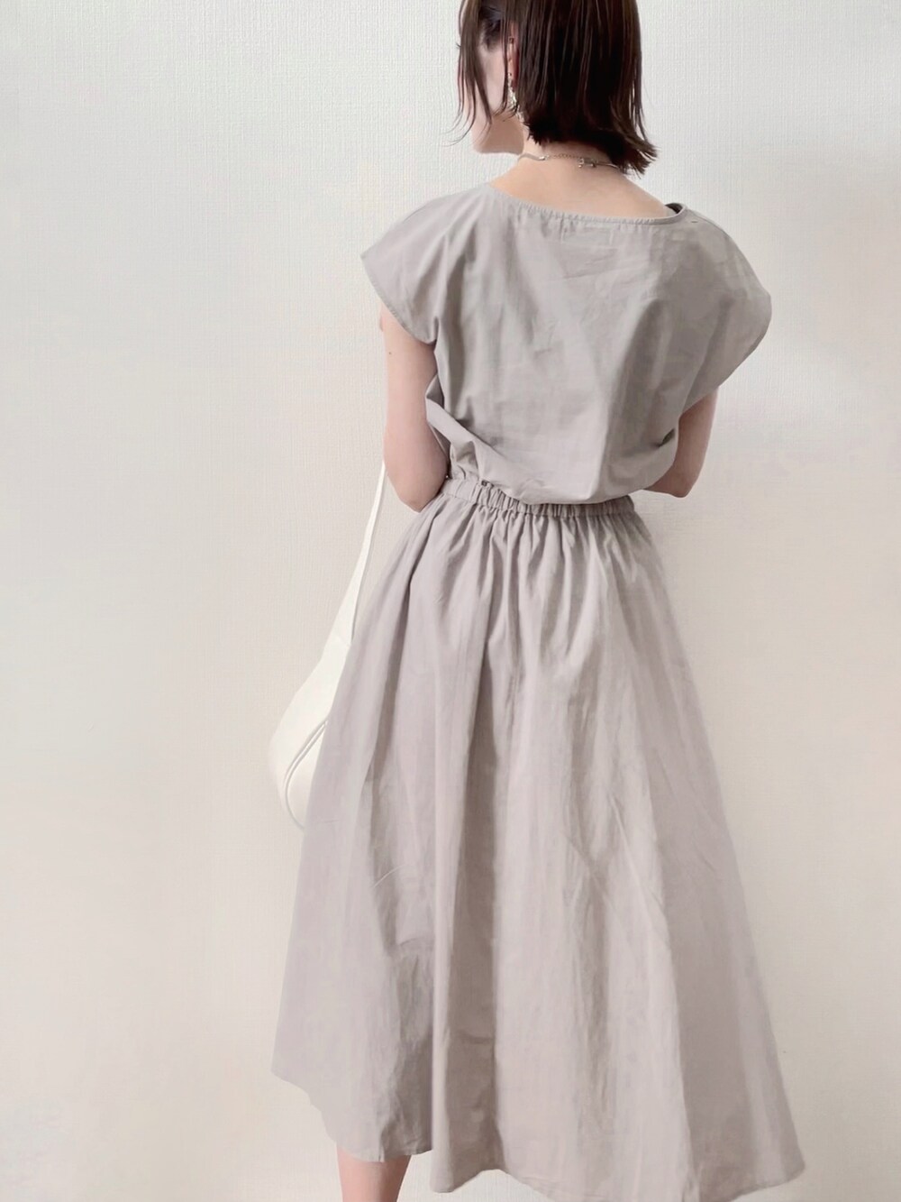 グレー系のワンピース、ホワイト系のサンダルを着用したレディースの夏コーディネートの3枚目の写真