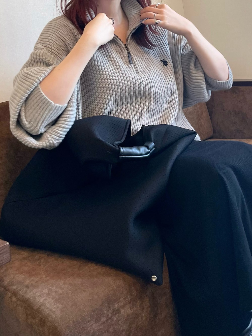 グレー系のニット/セーター、ブラック系のトートバッグを着用したレディースの冬コーディネートの2枚目の写真