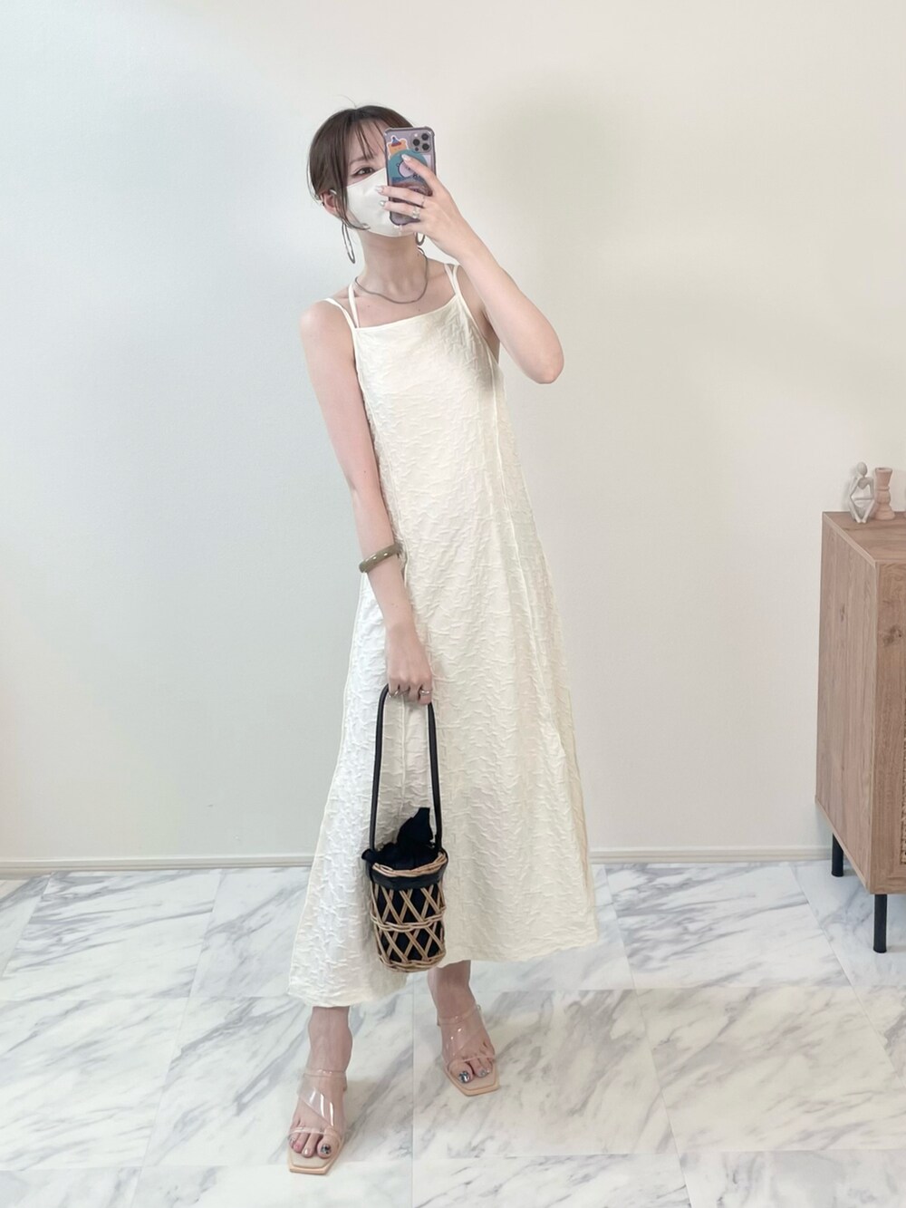 ホワイト系のワンピース、その他のサンダル、ブラック系のかごバッグを着用したレディースの秋コーディネートの3枚目の写真