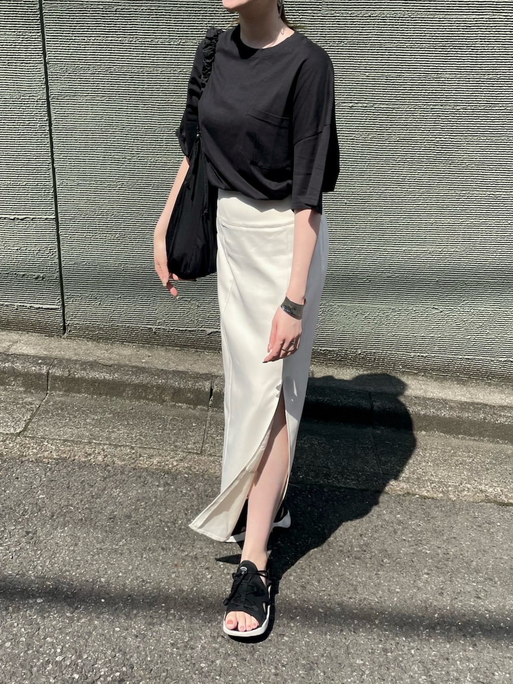 ブラック系のTシャツ/カットソー、ブラック系のショルダーバッグ、ブラック系のサンダルを着用したレディースの夏コーディネートの3枚目の写真