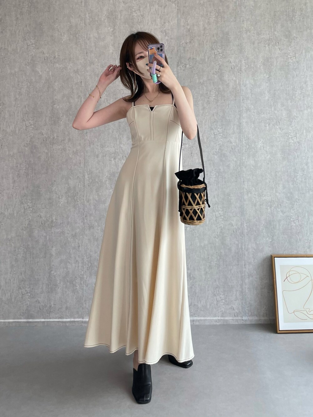 ホワイト系のワンピース、ブラック系のかごバッグ、ブラック系のローファーを着用したレディースの秋コーディネートの2枚目の写真