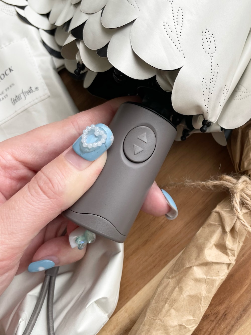 ホワイト系の折りたたみ傘を着用したレディースの夏コーディネートの5枚目の写真