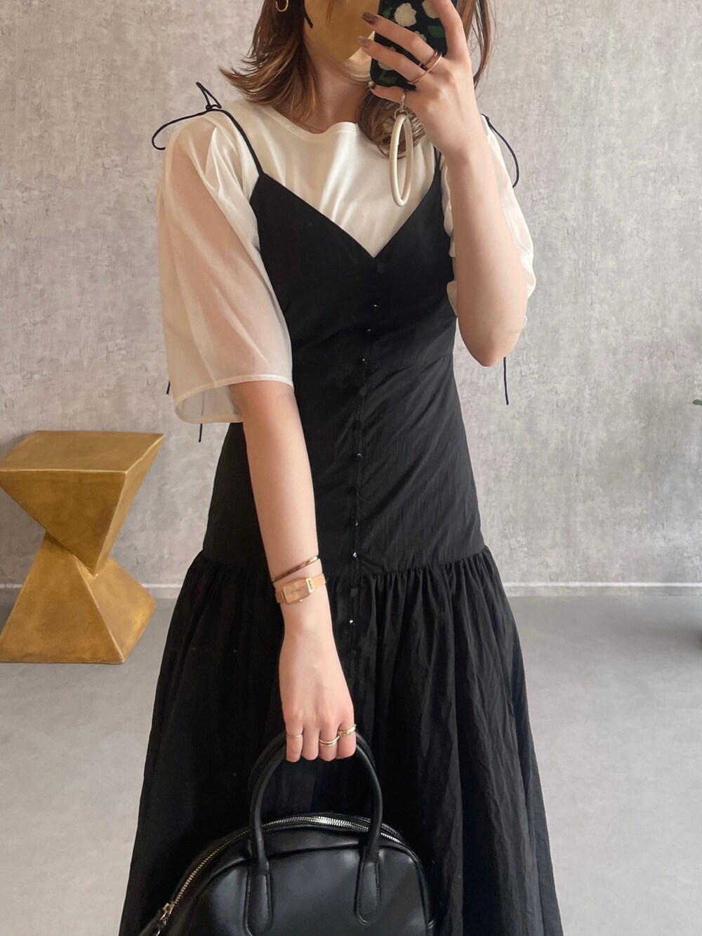 ホワイト系のシャツ/ブラウス、ブラック系のボストンバッグ、ブラック系のローファーを着用したレディースの夏コーディネートの2枚目の写真