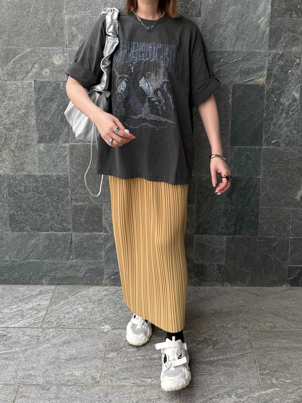 グレー系のTシャツ/カットソー、イエロー系のスカート、シルバー系のハンドバッグを着用したレディースの春コーディネートの2枚目の写真