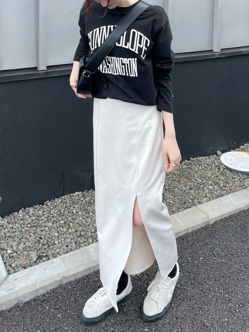 ブラック系のTシャツ/カットソー、ホワイト系のスニーカーを着用したレディースの秋コーディネートの3枚目の写真