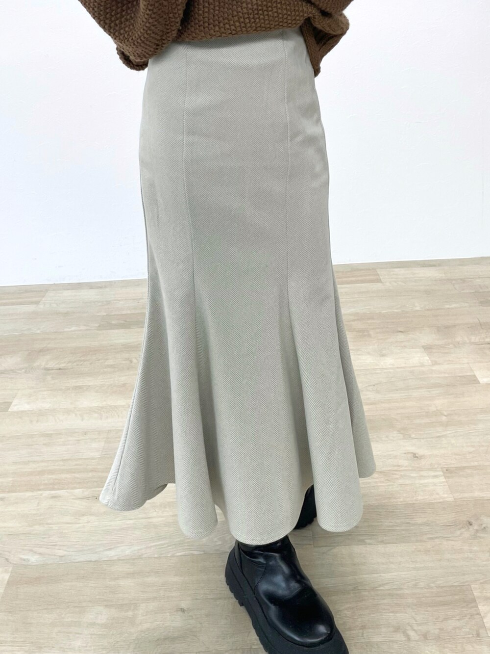 ホワイト系のスカート、イエロー系のニット/セーター、ブラック系のブーツを着用したレディースの冬コーディネートの3枚目の写真