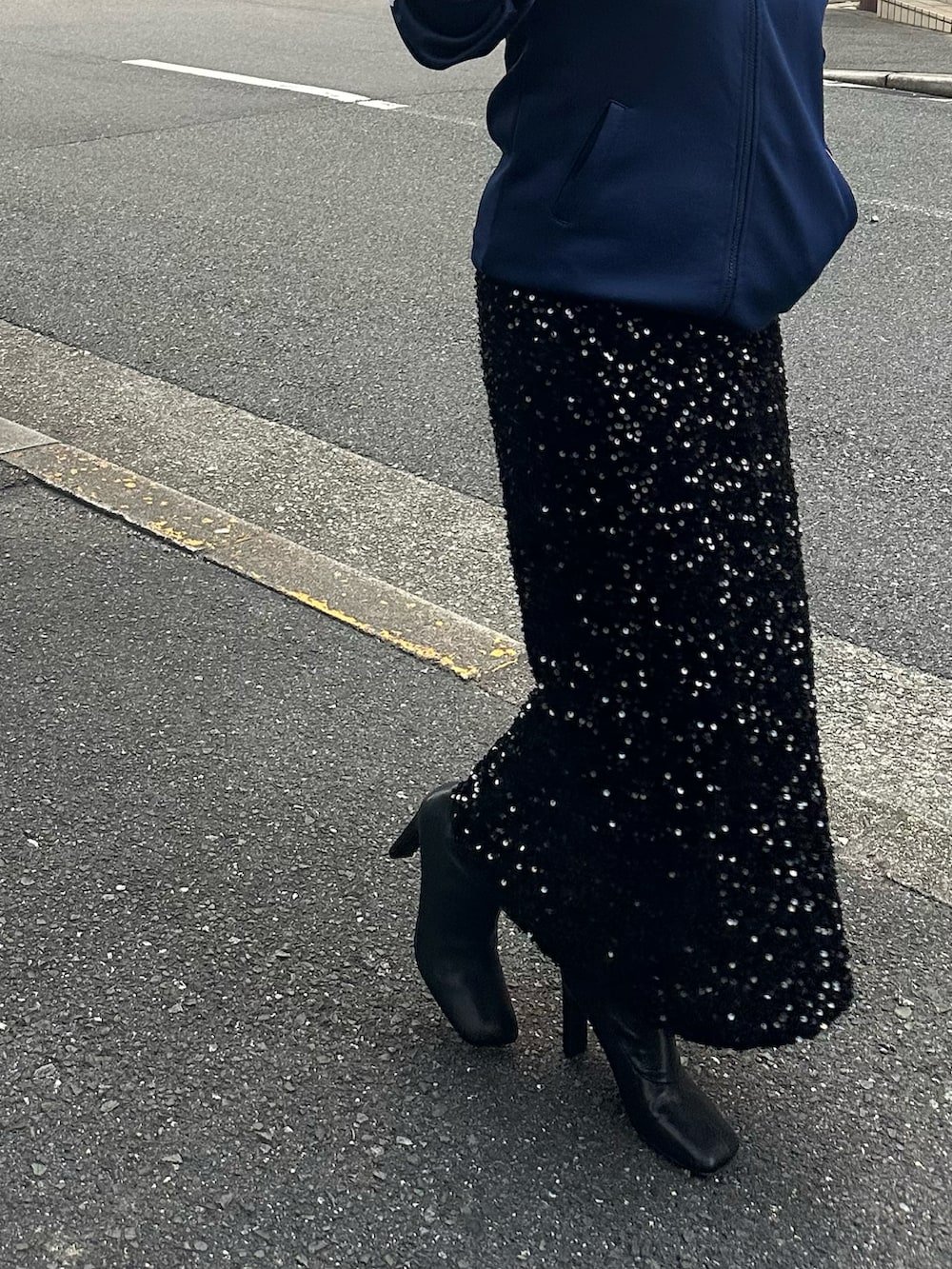 ブラック系のスカート、ブルー系のジャージ、ブラック系のブーツを着用したレディースの秋コーディネートの4枚目の写真