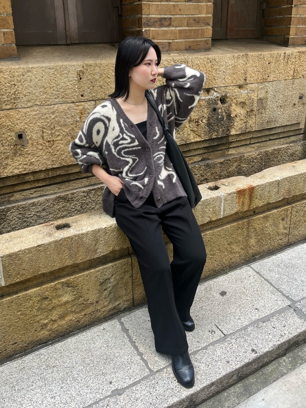 グレー系のカーディガン/ボレロ、ブラック系のトートバッグ、ブラック系のスラックスを着用したレディースの秋コーディネートの4枚目の写真