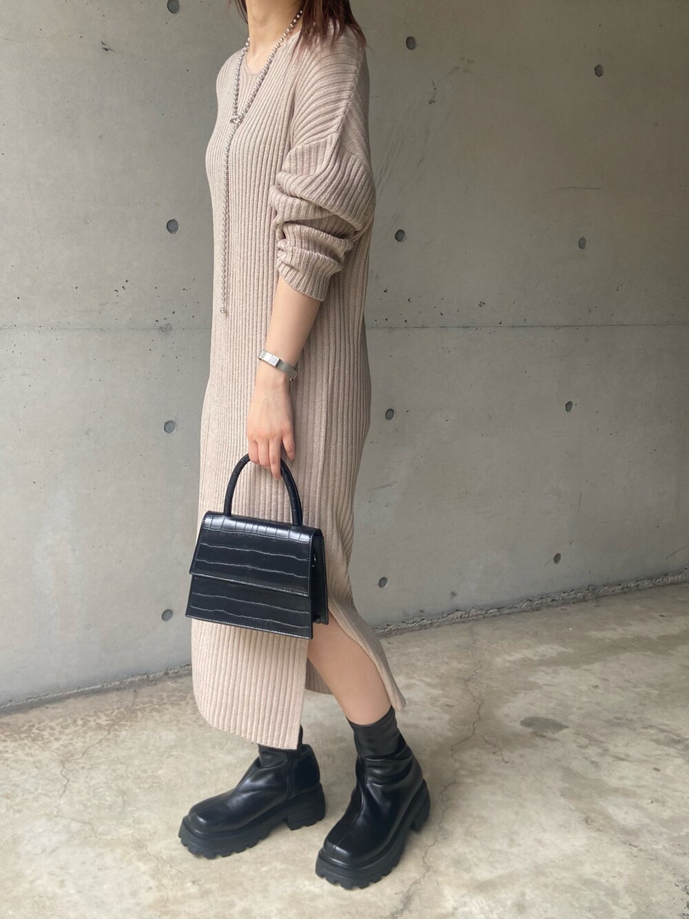ブラック系のショルダーバッグ、ベージュ系のワンピース、ブラック系のブーツを着用したレディースの秋コーディネートの3枚目の写真